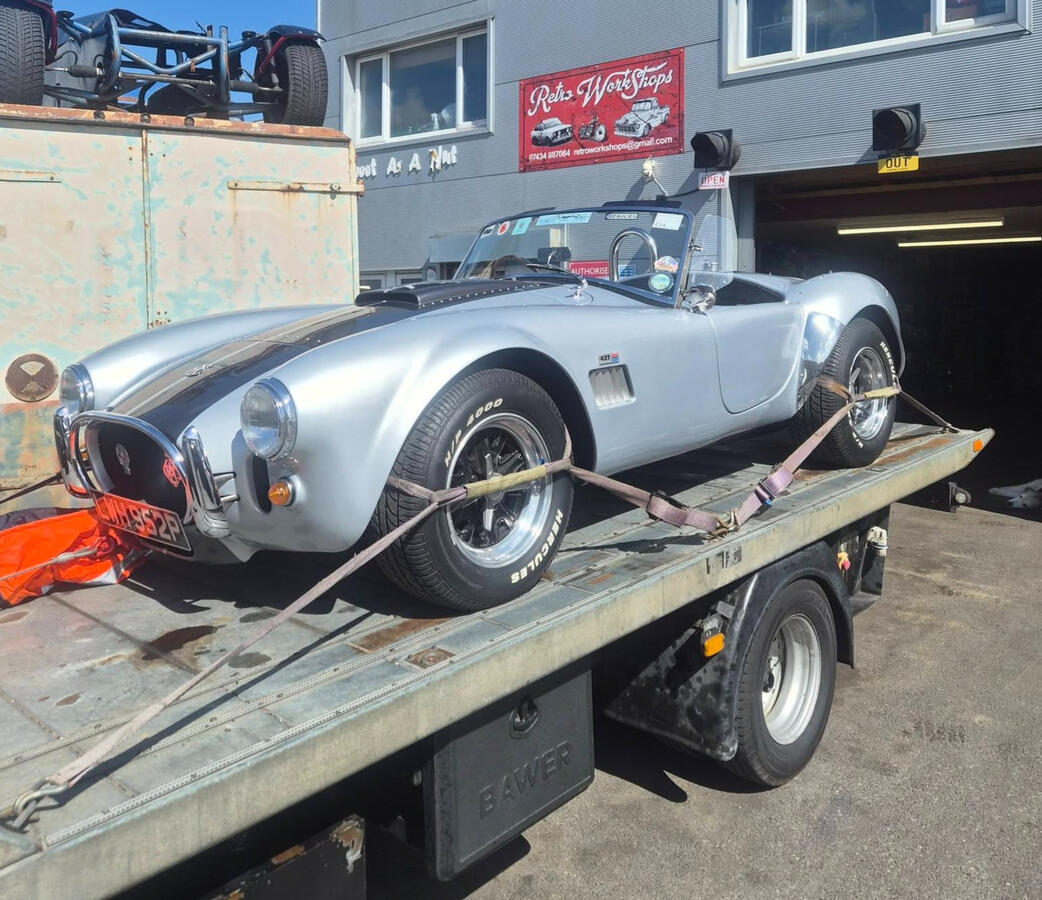Silver AC Cobra Silver AC Cobra with black stripe on car transported being delivered to workshop
